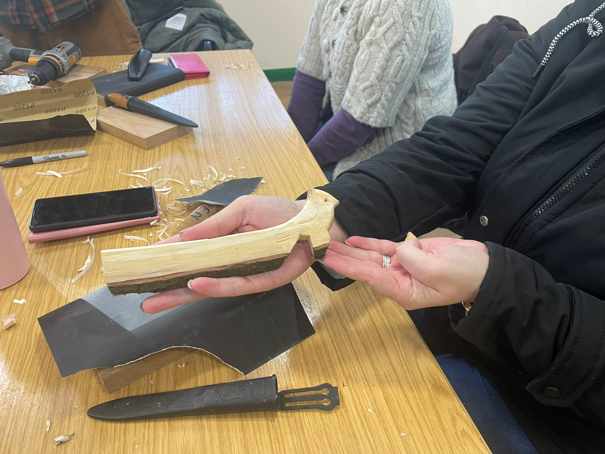 People sharing practical and creative skills around a table