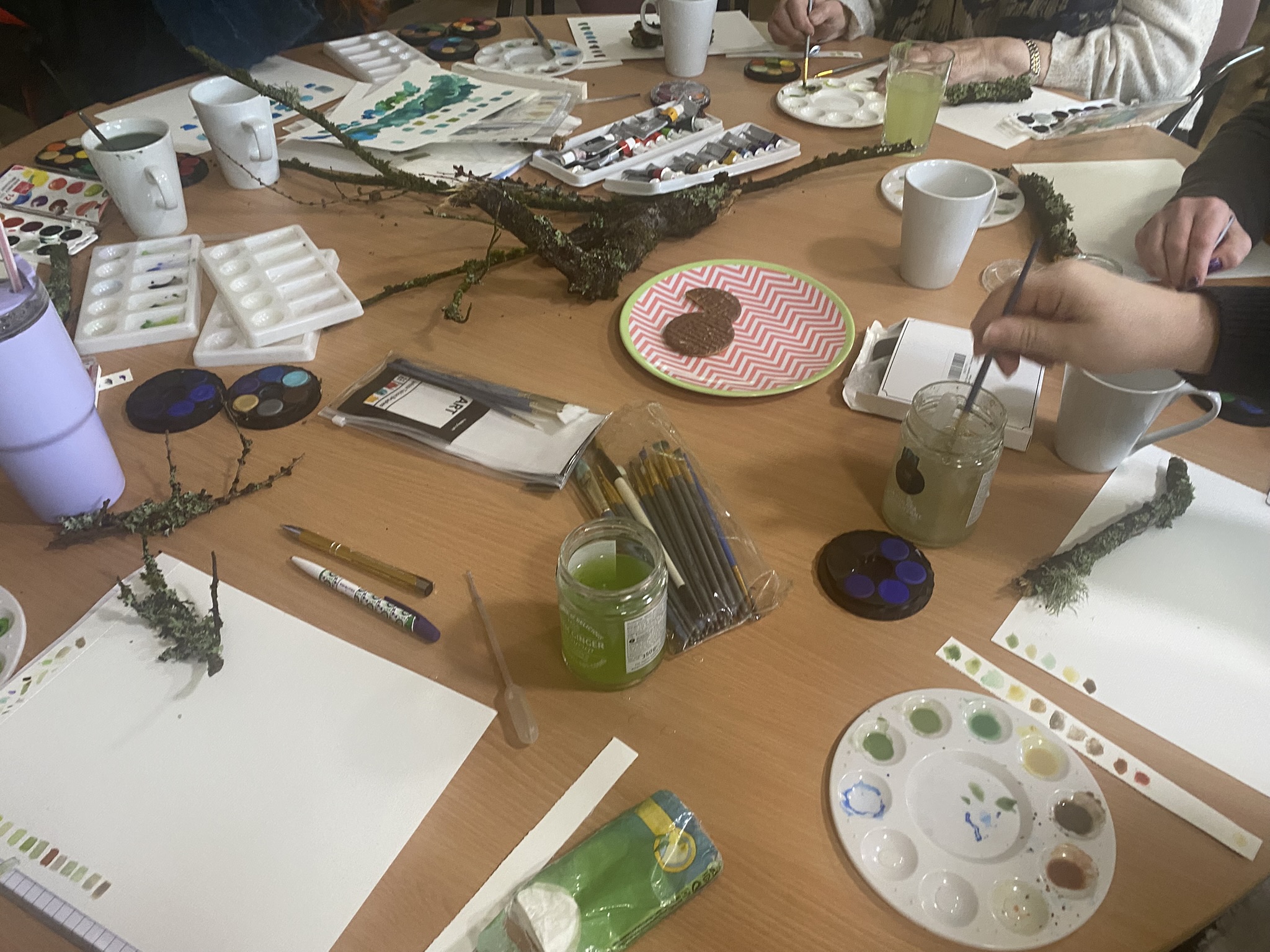 Hands using natural materials and art supplies during a practical session