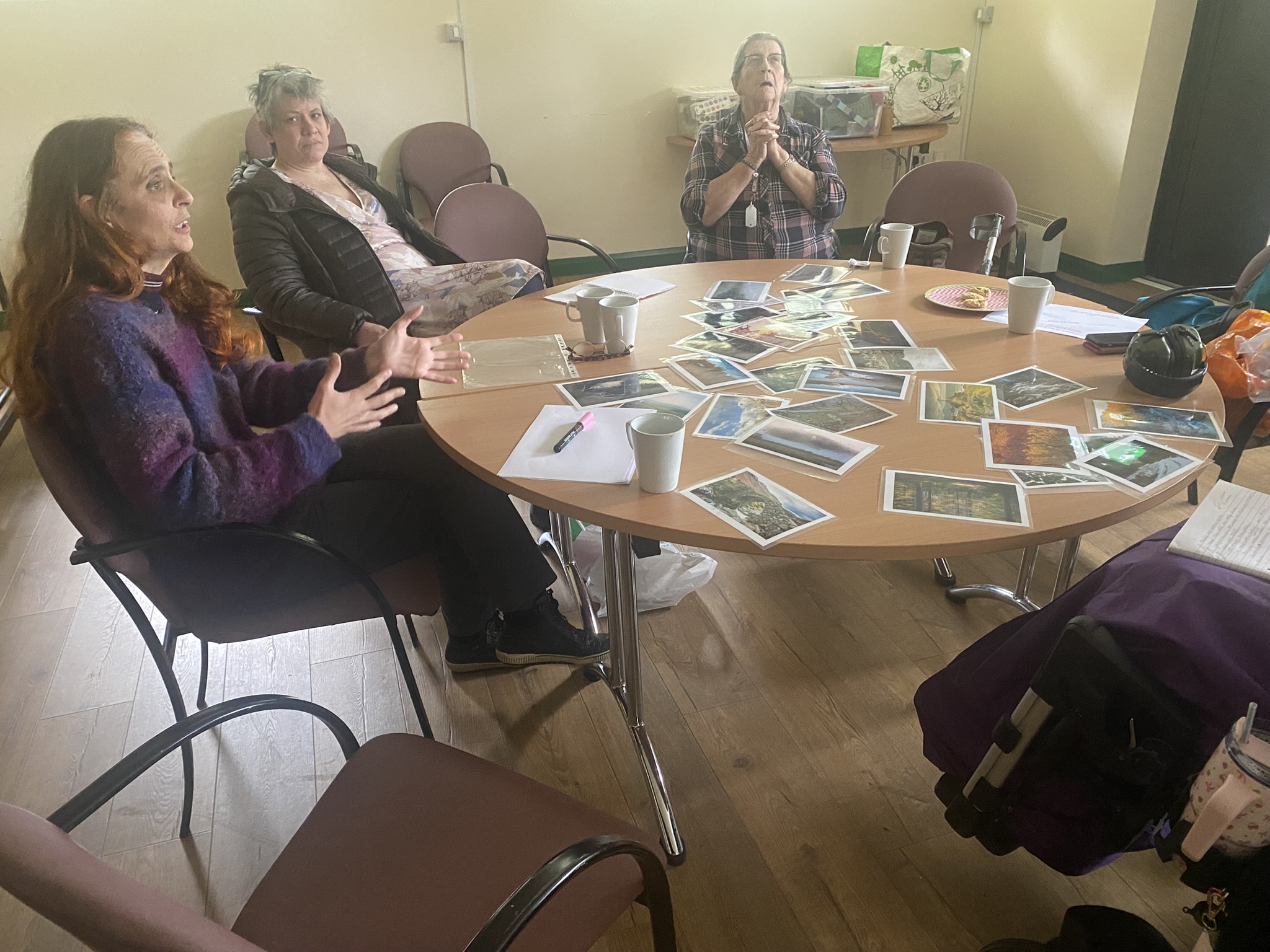 People talking together around a table covered with photographs