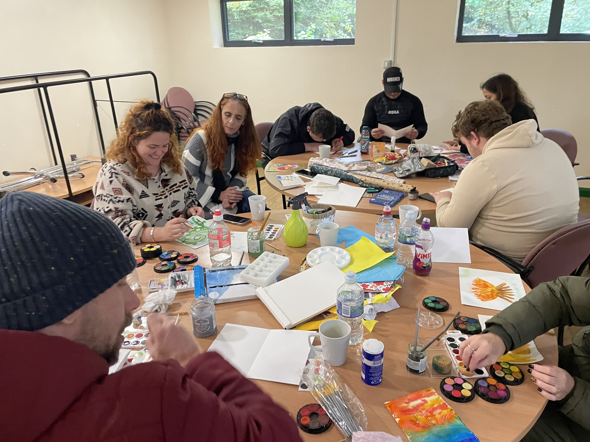 People taking part in a colourful arts activity around a table