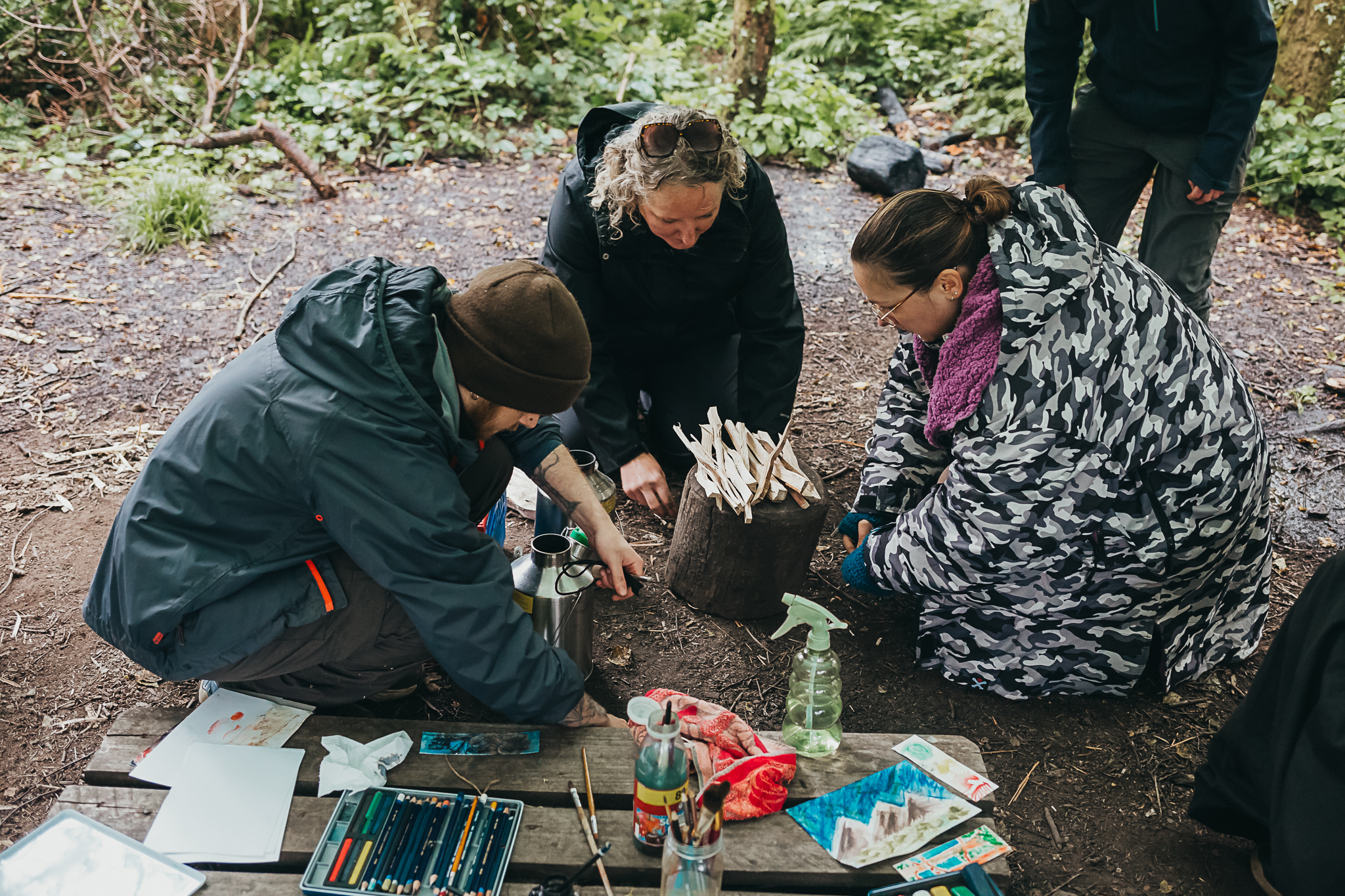 A participant learning practical fire-lighting skills outdoors